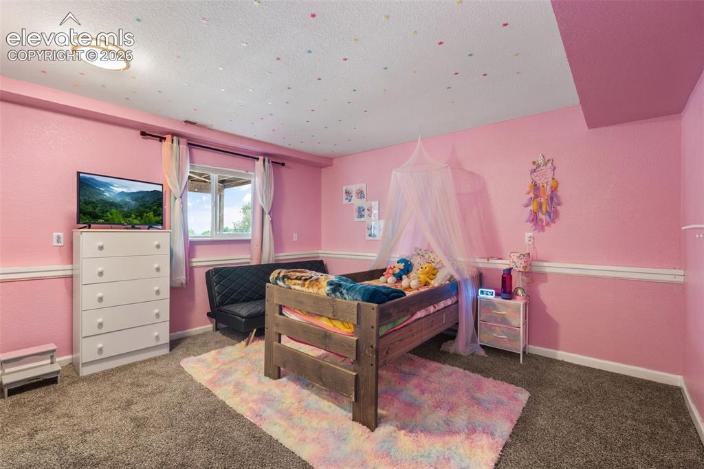 Image 28 of 43: Carpeted interior space featuring a window with exterior views, crown moldi