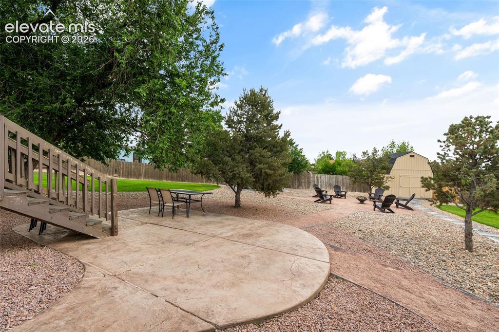 Image 31 of 43: Expansive outdoor living area featuring a stamped concrete patio, stone agg