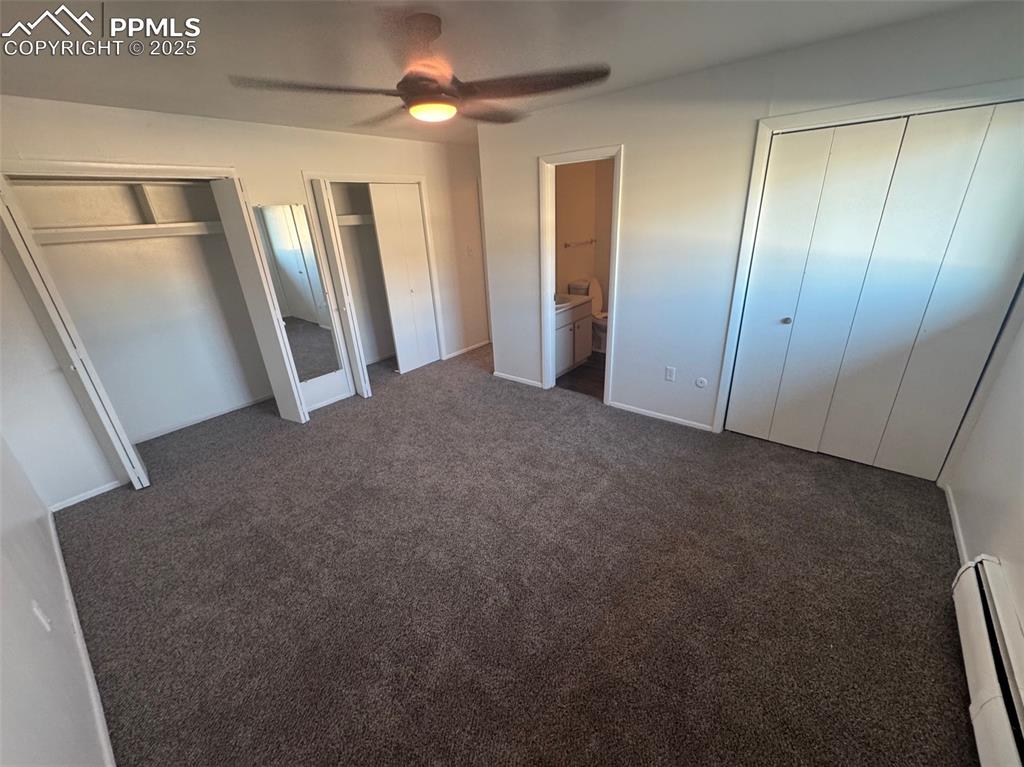 Image 12 of 30: Unfurnished bedroom featuring multiple closets, a baseboard radiator, conne