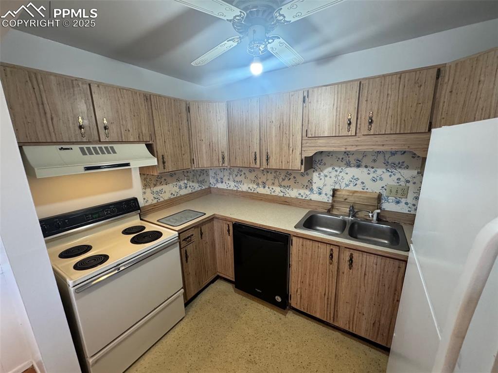 Image 8 of 30: Kitchen featuring white appliances, light countertops, extractor fan, and c