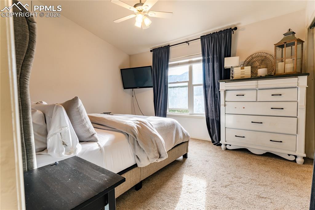 Image 17 of 23: Bedroom featuring light colored carpet, ceiling fan, and lofted ceiling