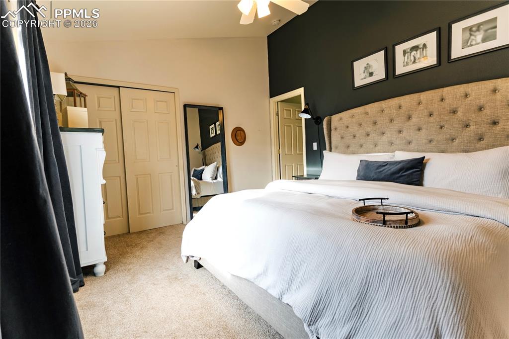 Image 18 of 23: Bedroom featuring light colored carpet, vaulted ceiling, a closet, and a ce
