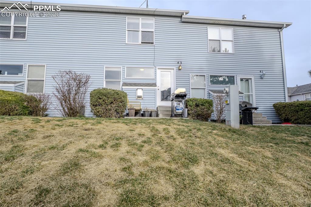 Image 20 of 23: Back of house with a yard