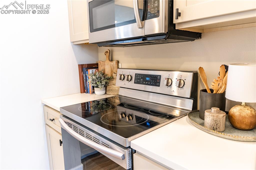 Image 8 of 23: Kitchen featuring stainless steel appliances, light countertops, and white