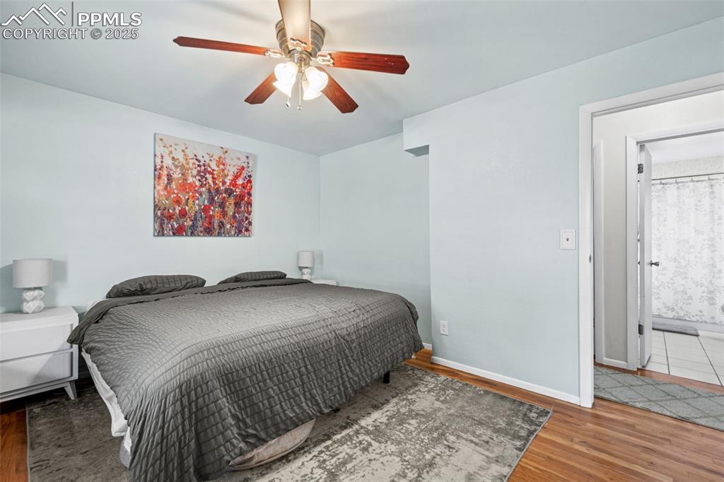 Image 12 of 33: Bedroom with wood finished floors and ceiling fan