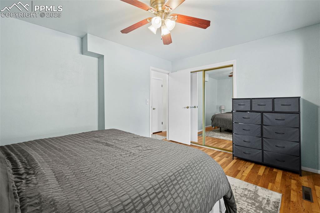 Image 13 of 33: Bedroom featuring wood finished floors, a ceiling fan, and a closet