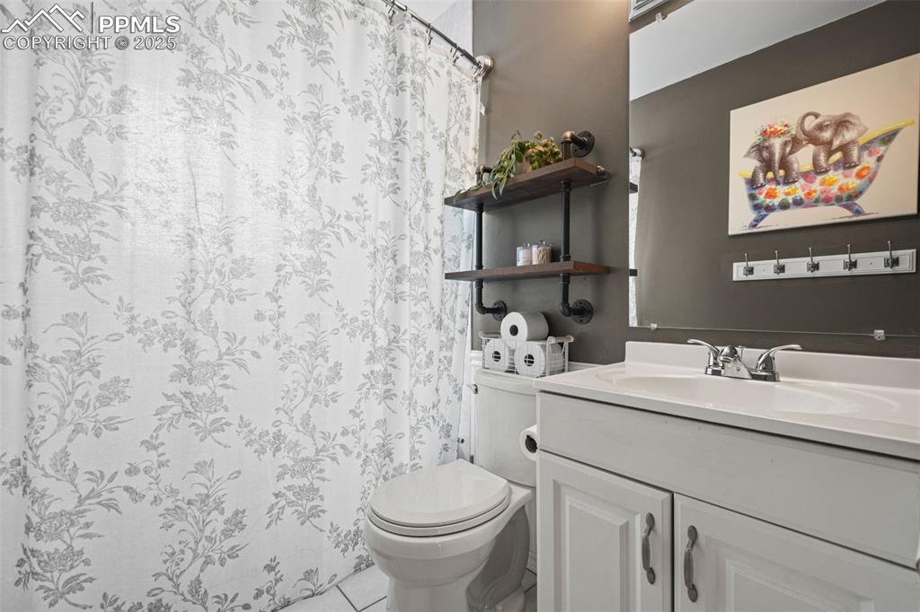Image 14 of 33: Bathroom with vanity, light tile patterned flooring, and a shower with curt