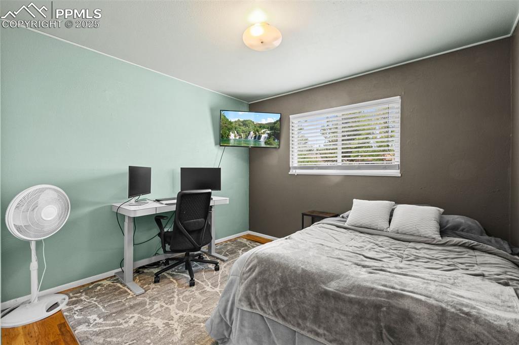 Image 15 of 33: Bedroom featuring wood finished floors and a desk