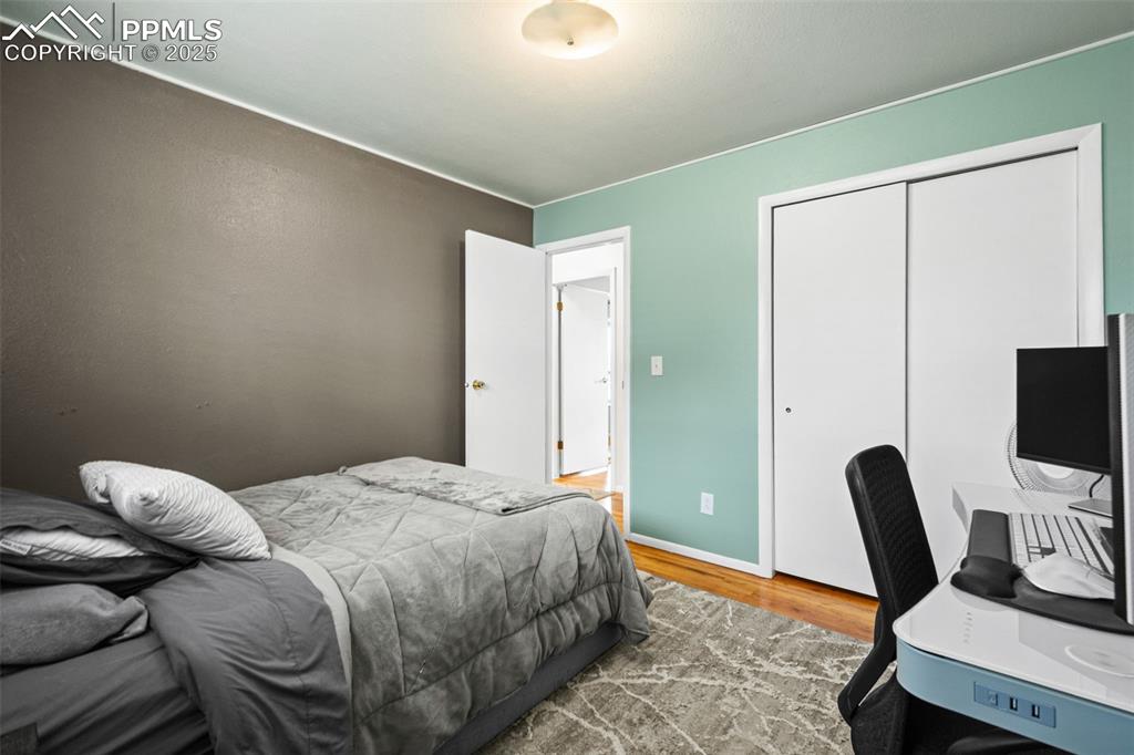 Image 16 of 33: Bedroom with wood finished floors, a closet, and a desk