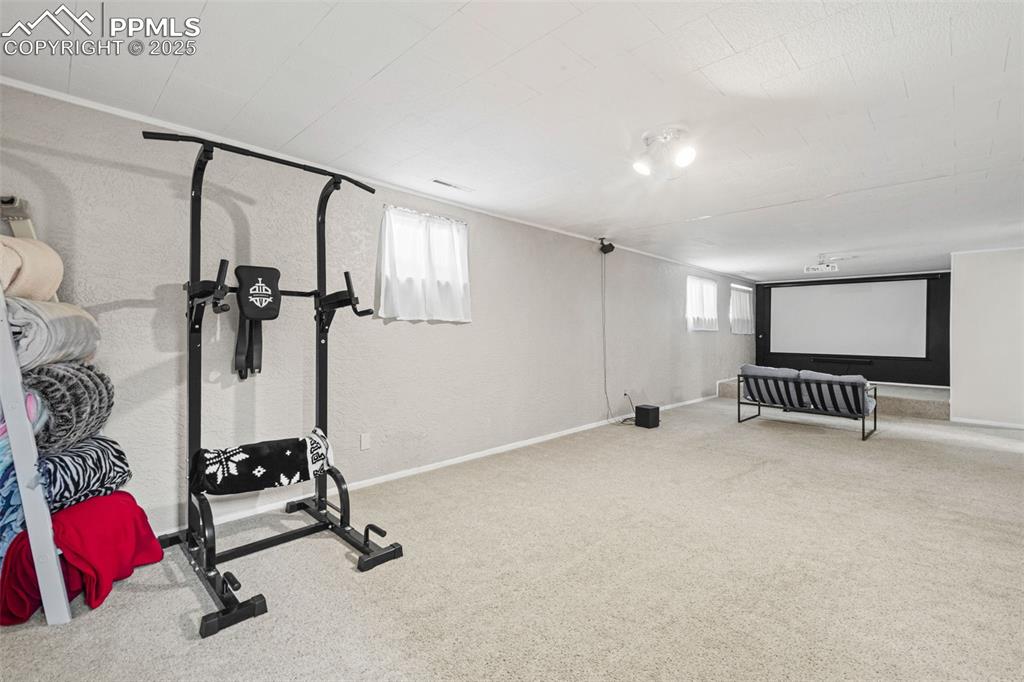 Image 21 of 33: Exercise area featuring light colored carpet and a textured wall