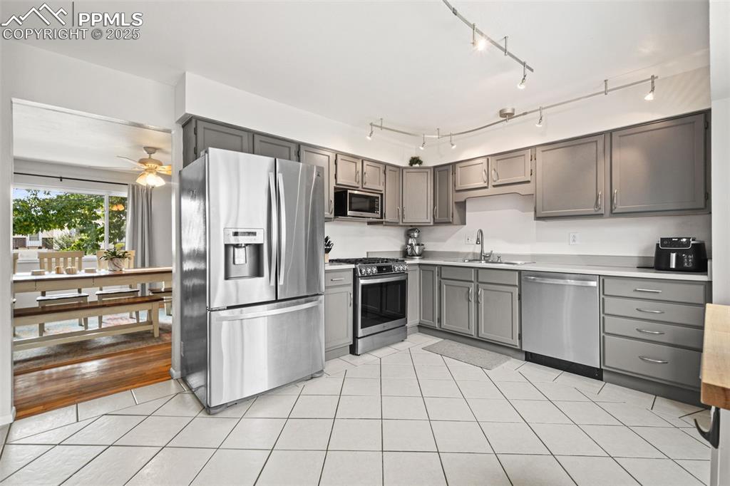 Image 7 of 33: Kitchen featuring stainless steel appliances, light countertops, gray cabin