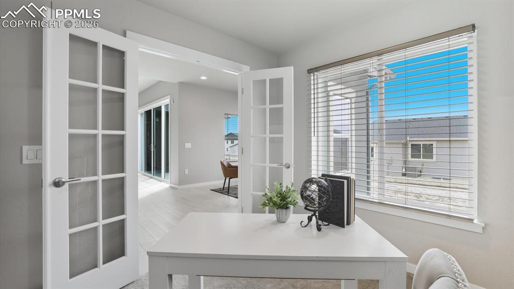 Image 14 of 50: Main Level Office with neutral carpet and window with window blinds.