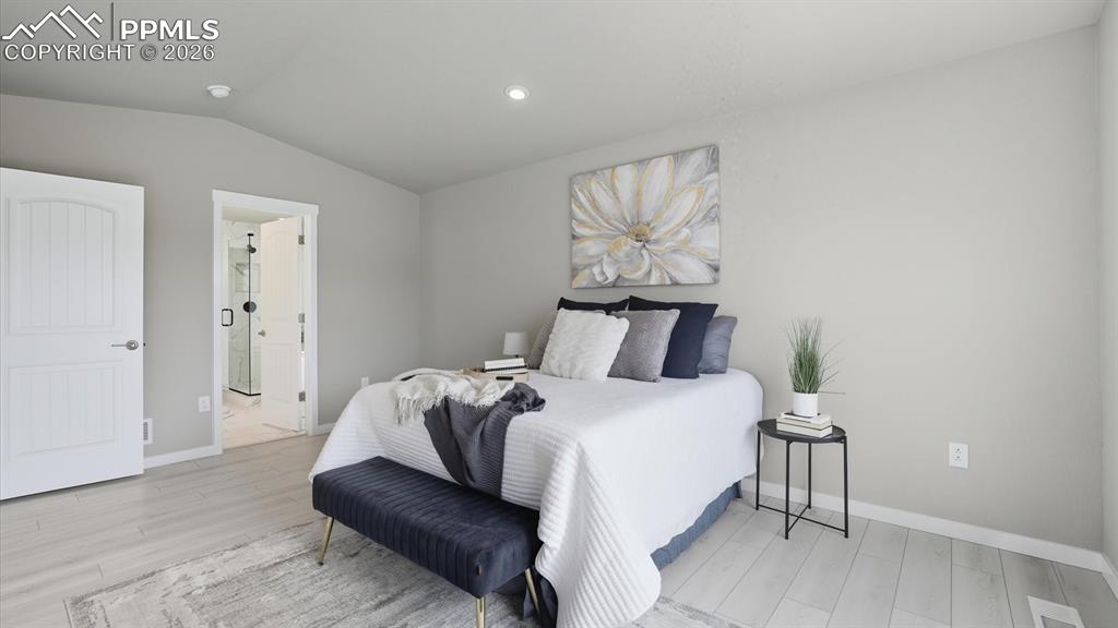 Image 21 of 50: Vaulted Main level Primary Suite with neutral carpet, adjoining 5-piece Bat