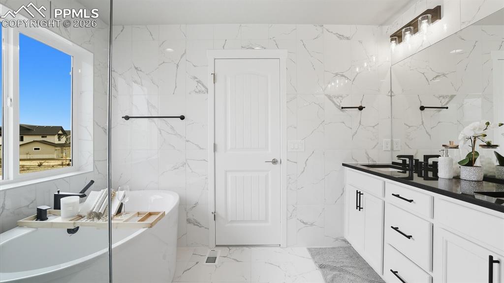Image 24 of 50: Soaking tub and tiled shower with built-in seat in the Primary Bathroom.