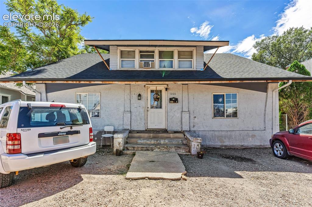 Caption: Stucco exterior with a pitched shingle roof