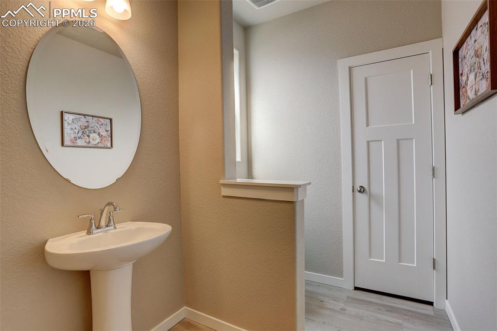 Image 10 of 50: Main level Bathroom, pony wall, with pedestal sink, and linen closet - this