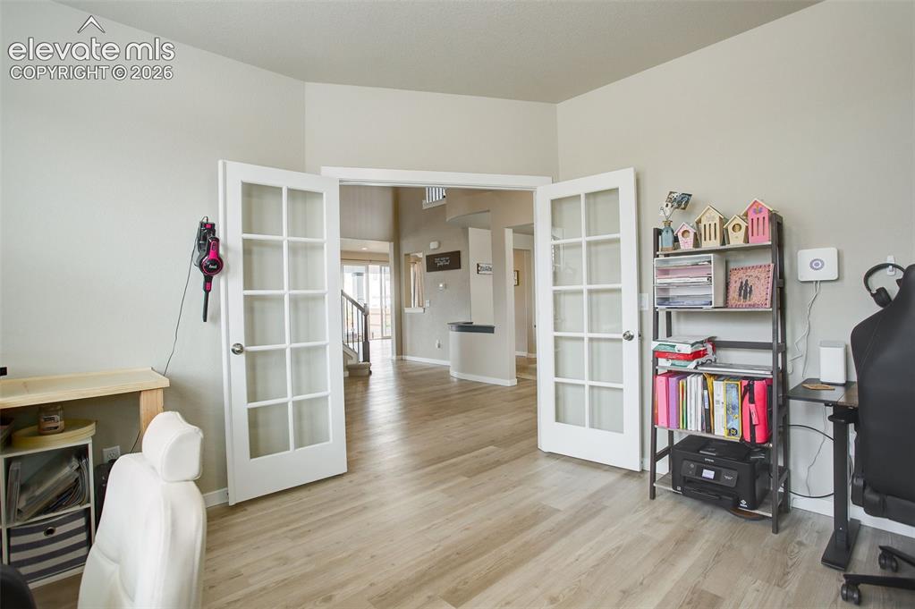 Image 10 of 50: Main level office; french doors, LVP flooring, and loads of natural light