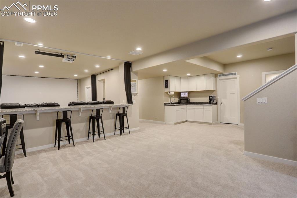 Image 12 of 50: Lower level; basement - counter-height stone top seating/entertainment area