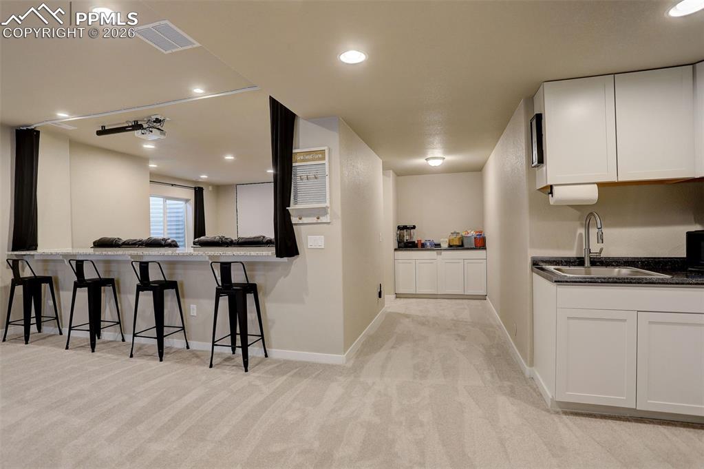 Image 13 of 50: Lower level/basement living area featuring recessed lighting and large wind