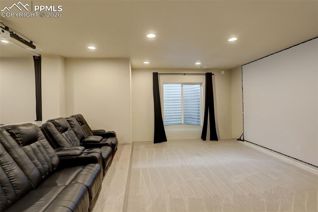 Image 14 of 50: Theater area, with raised platform for theater seating, ceiling mounted pro