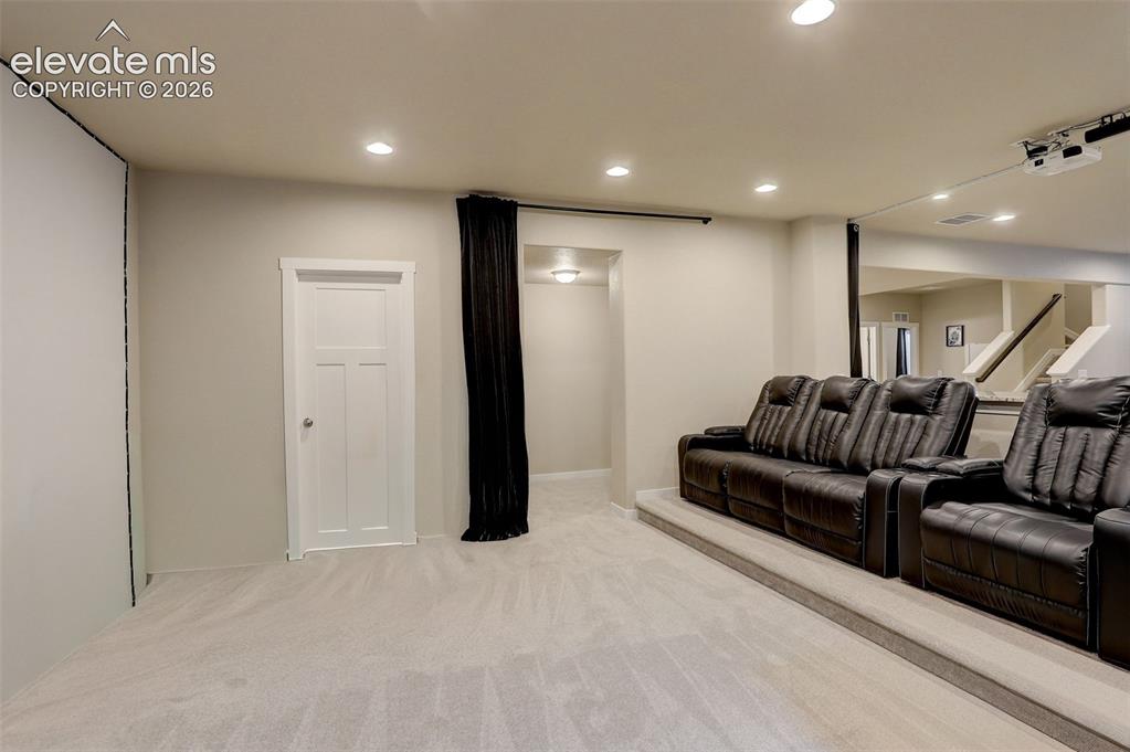Image 14 of 50: Theater area, with raised platform for theater seating, ceiling mounted pro