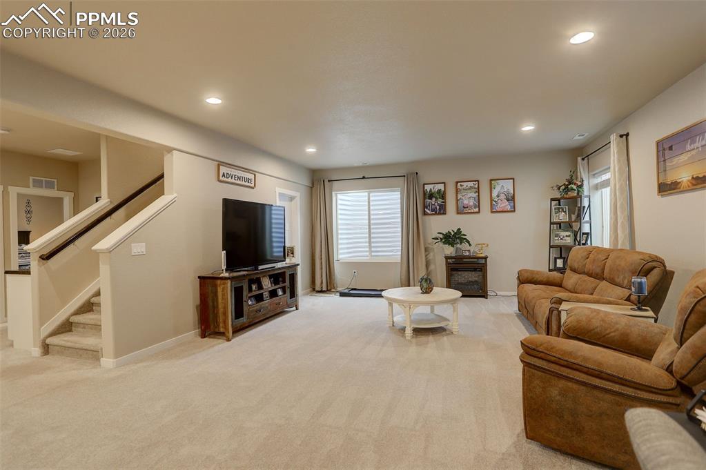 Image 16 of 50: Lower Level; Living room, oversized windows, and deep walk-in storage close