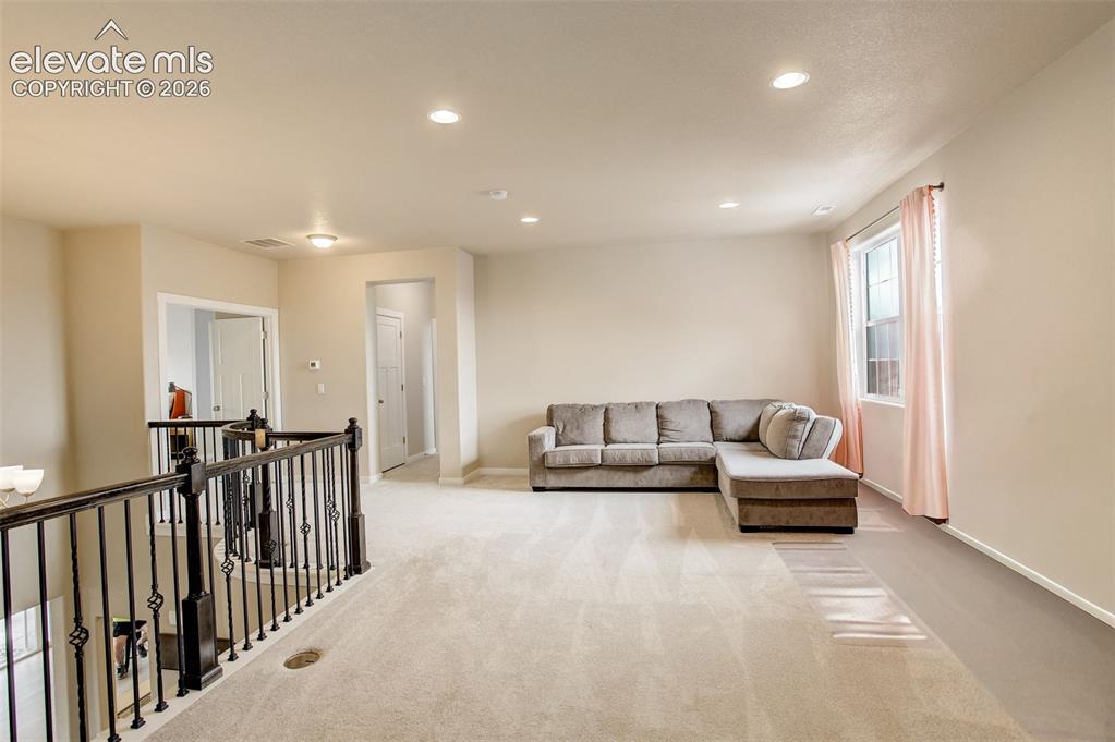Image 18 of 50: Living room with recessed lighting and carpet, spacious and bright