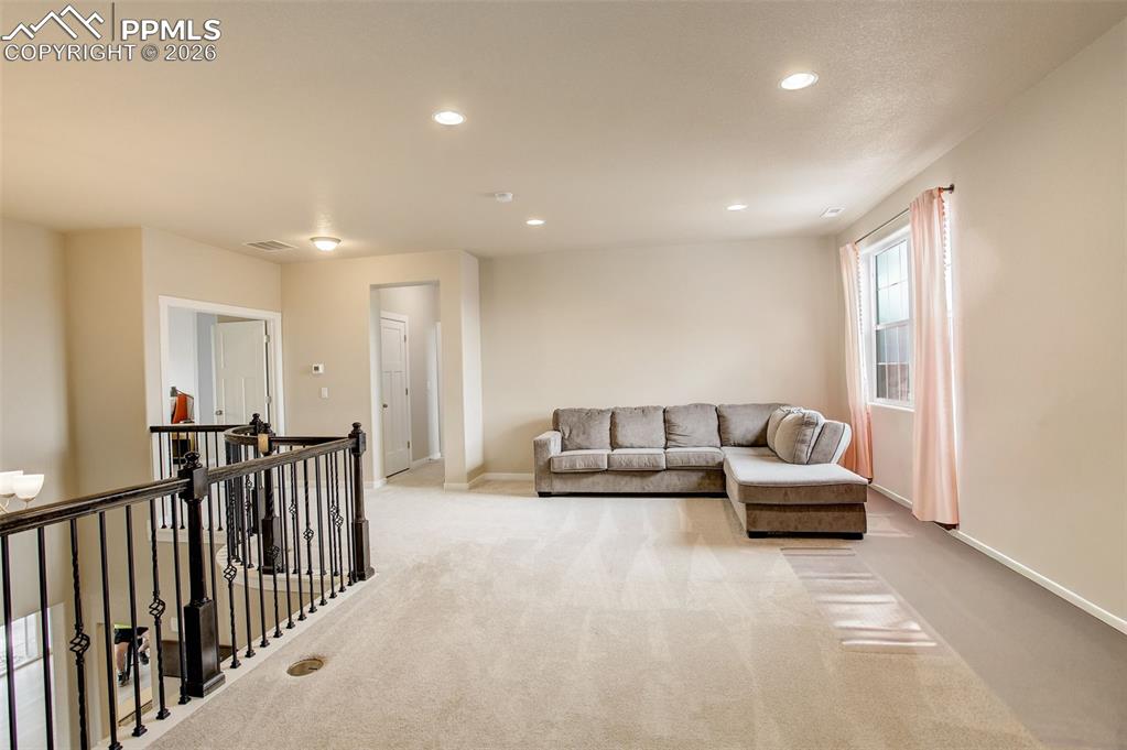 Image 19 of 50: Living room with recessed lighting and carpet, spacious and bright 