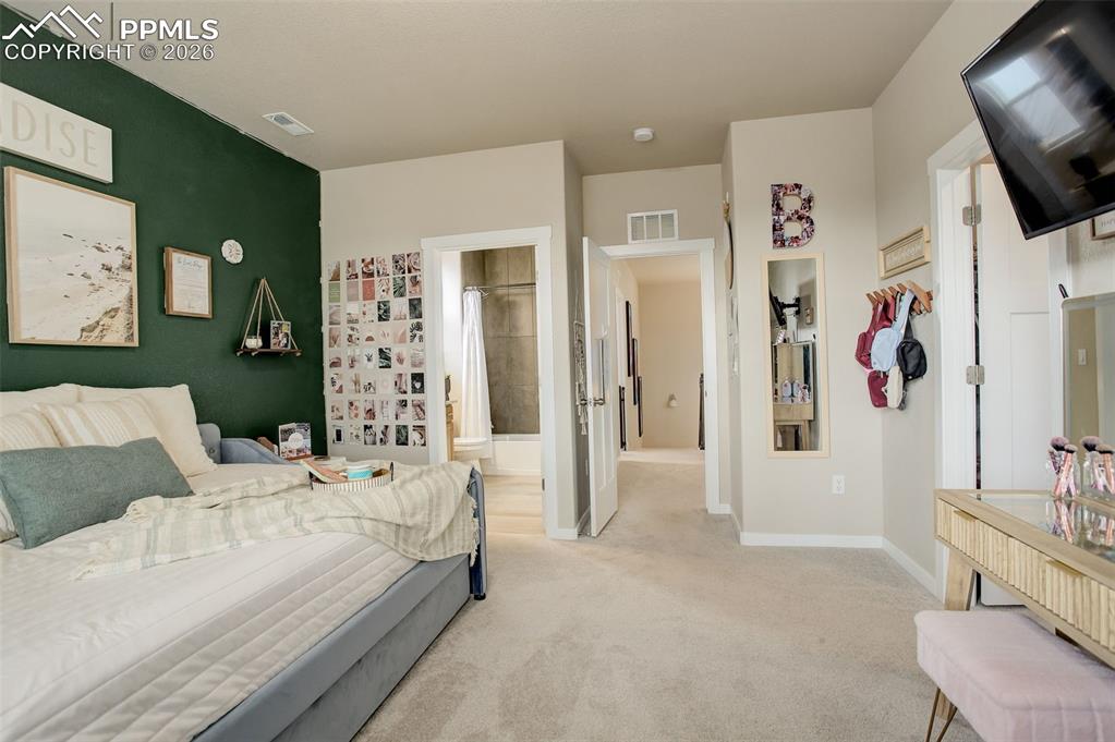 Image 22 of 50: Adjoining bathroom. Full bathroom featuring stone vanity, shower/tub with t