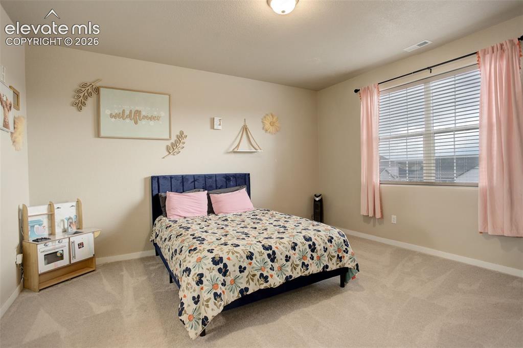 Image 23 of 50: Bedroom with light carpet and ensuite bath