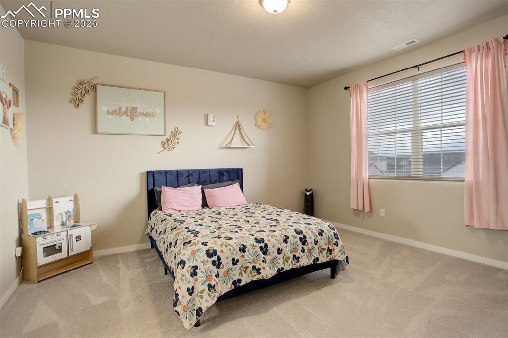 Image 24 of 50: Bedroom with light carpet and ensuite bath