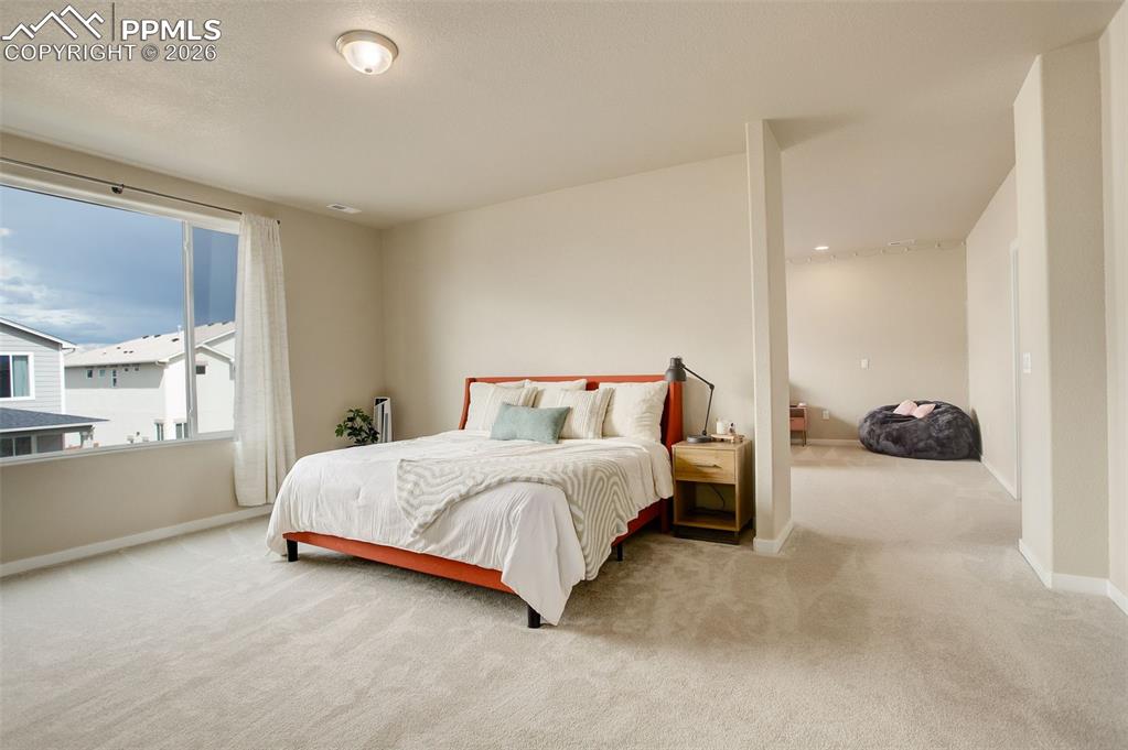 Image 27 of 50: The upper-level primary suite is a true retreat, highlighted by a panoramic