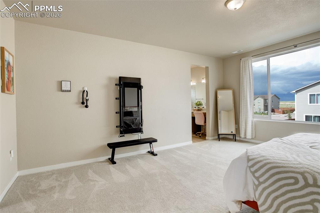 Image 28 of 50: Carpeted bedroom featuring baseboards and connected bathroom