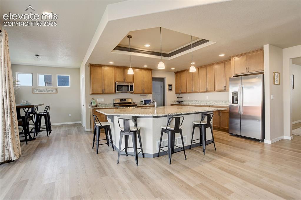 Image 38 of 50: Kitchen with stainless steel appliances, a raised ceiling, a kitchen breakf