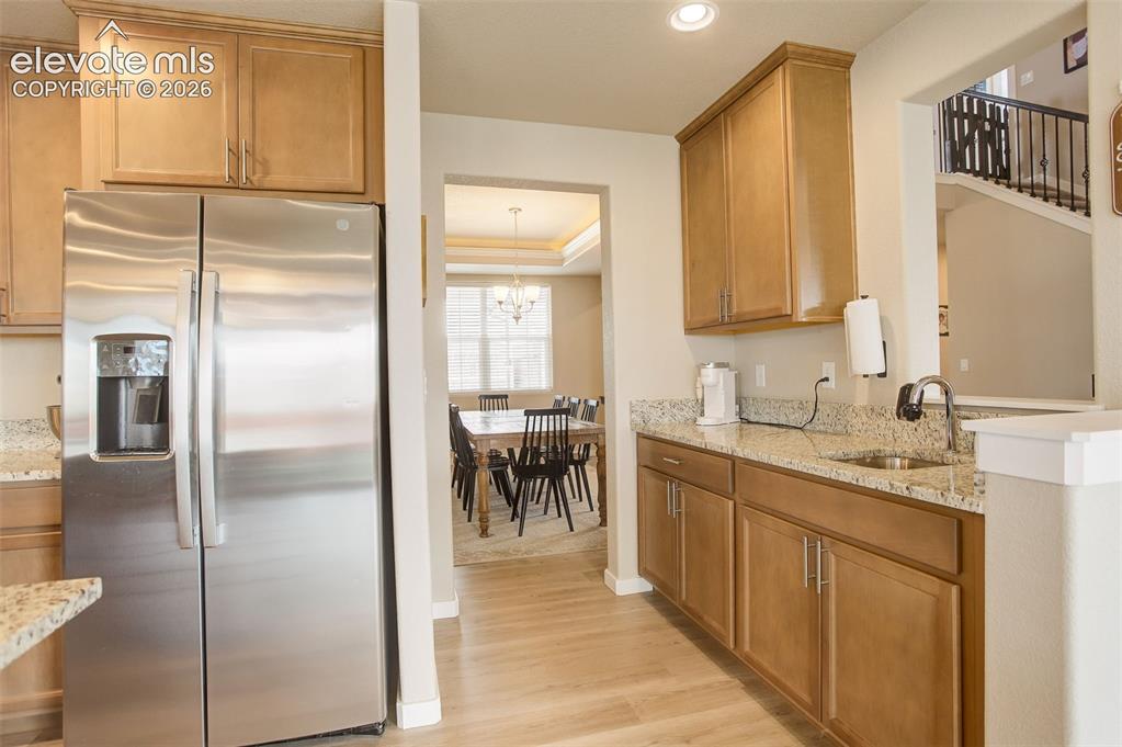 Image 40 of 50: Kitchen featuring stainless steel refrigerator with ice dispenser, light st