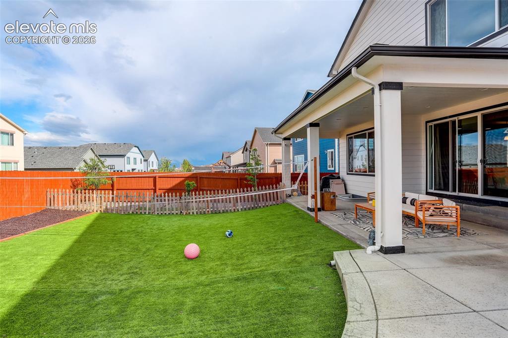Image 43 of 50: Fenced backyard featuring a patio area, turf - extended concrete patio.