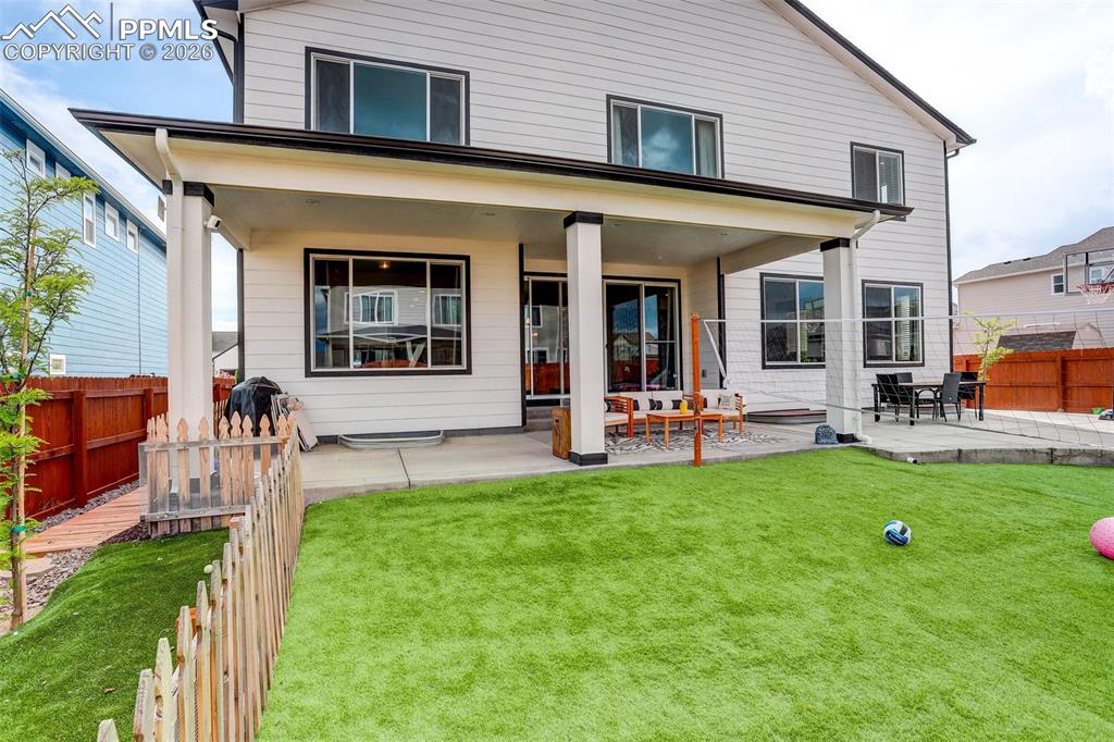 Image 44 of 50: Rear view of house featuring a fenced backyard and a covered patio