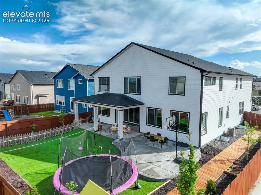 Image 44 of 50: Back of house with a patio area, a trampoline, a fenced backyard, and a res