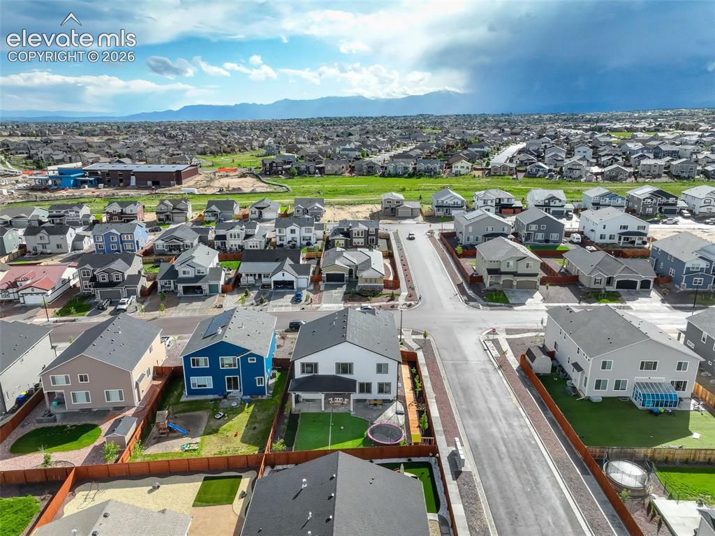 Image 45 of 50: Aerial view of residential area with a mountain backdrop