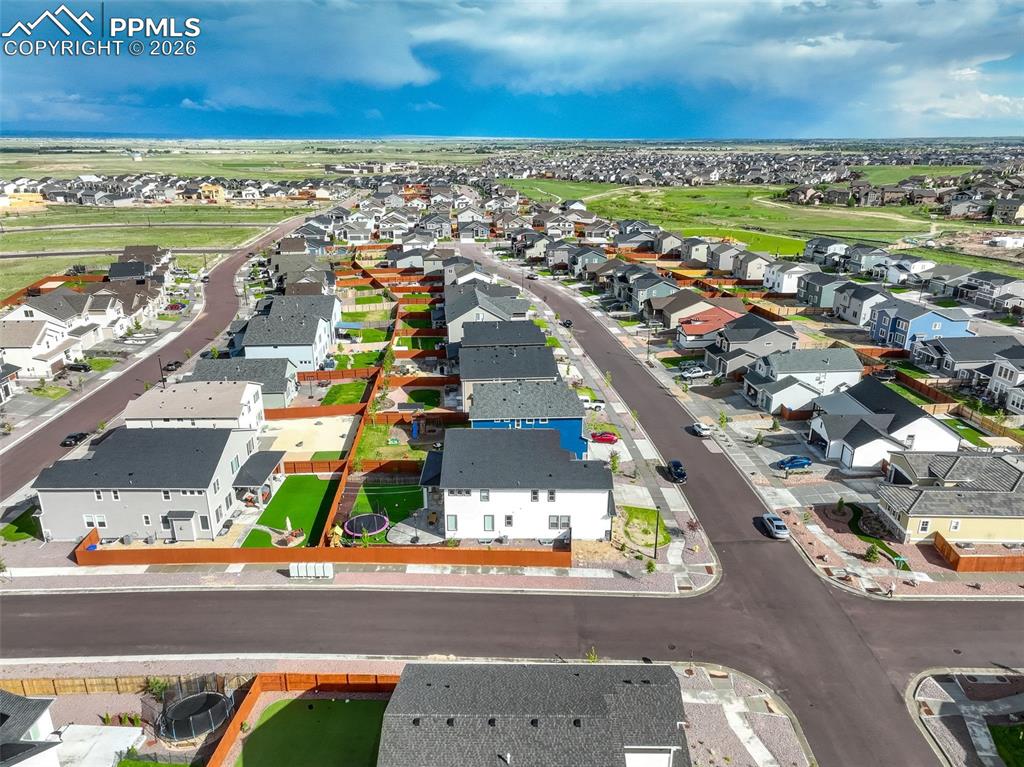 Image 5 of 50: Aerial view of Craftsman house featuring two attached garages, concrete dri