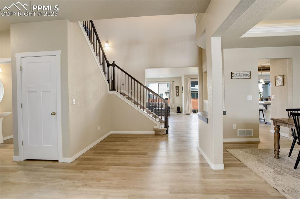 Image 9 of 50: Foyer entrance featuring white oak LVP flooring, grand entry with 16+ft cei