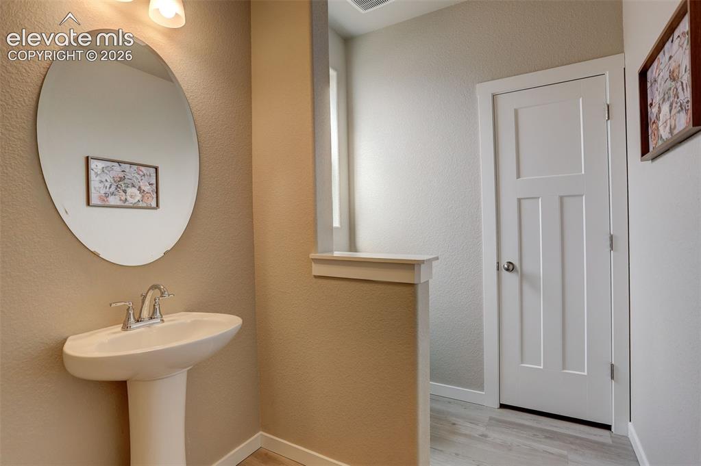 Image 9 of 50: Main level Bathroom, pony wall, with pedestal sink, and linen closet - this
