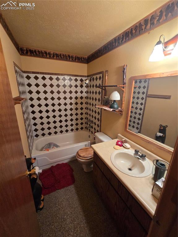 Image 11 of 23: Bathroom featuring vanity, a textured ceiling, and shower / tub combination