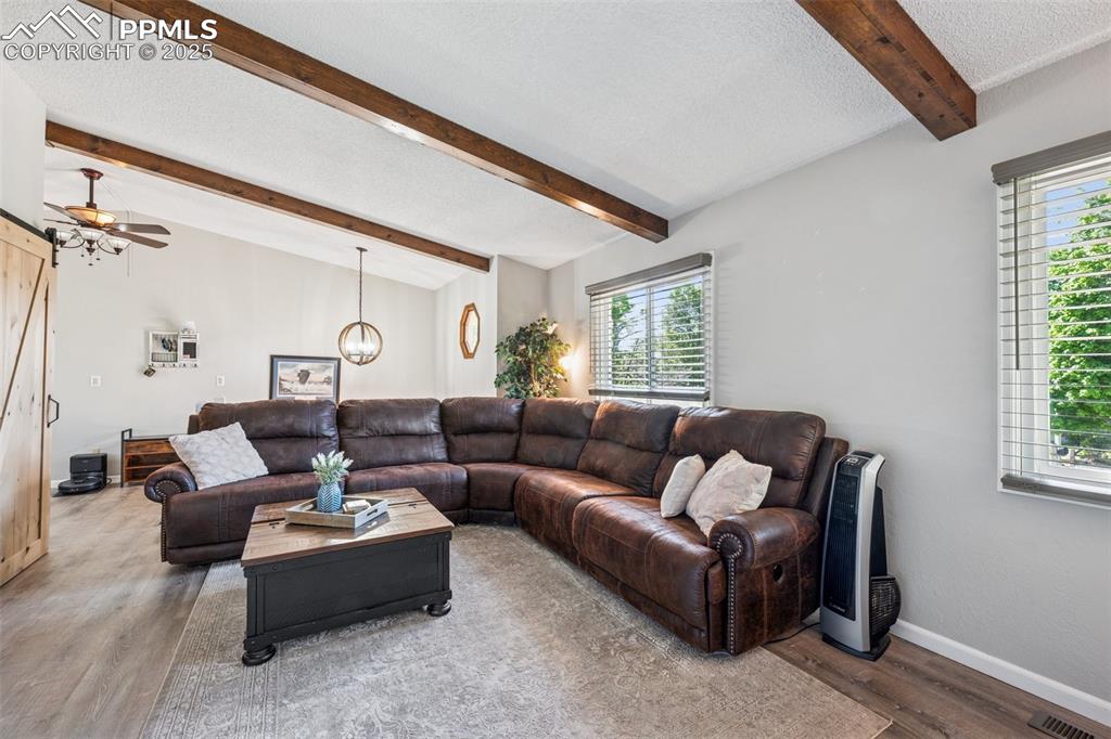 Image 10 of 25: Living room featuring a textured ceiling, wood finished floors, ceiling fan