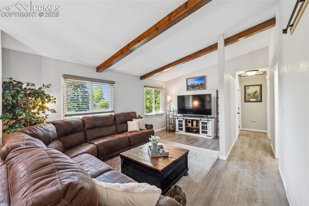 Image 11 of 25: Living room featuring wood finished floors and baseboards