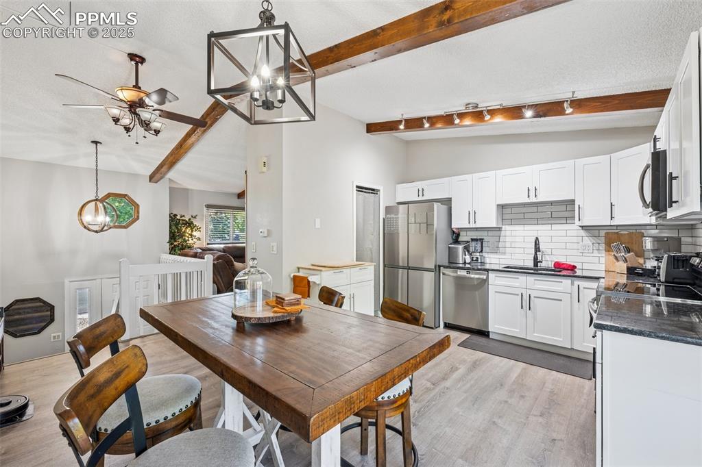 Image 14 of 25: Dining room with a chandelier and light wood-type flooring