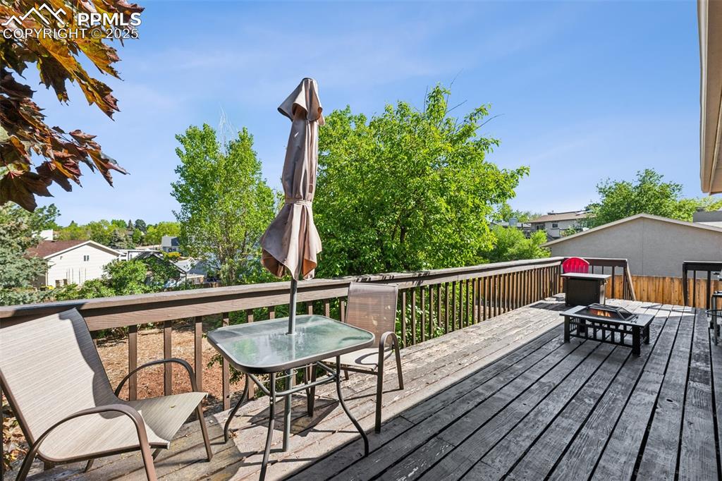 Image 2 of 25: Wooden deck with a fire pit and outdoor dining space