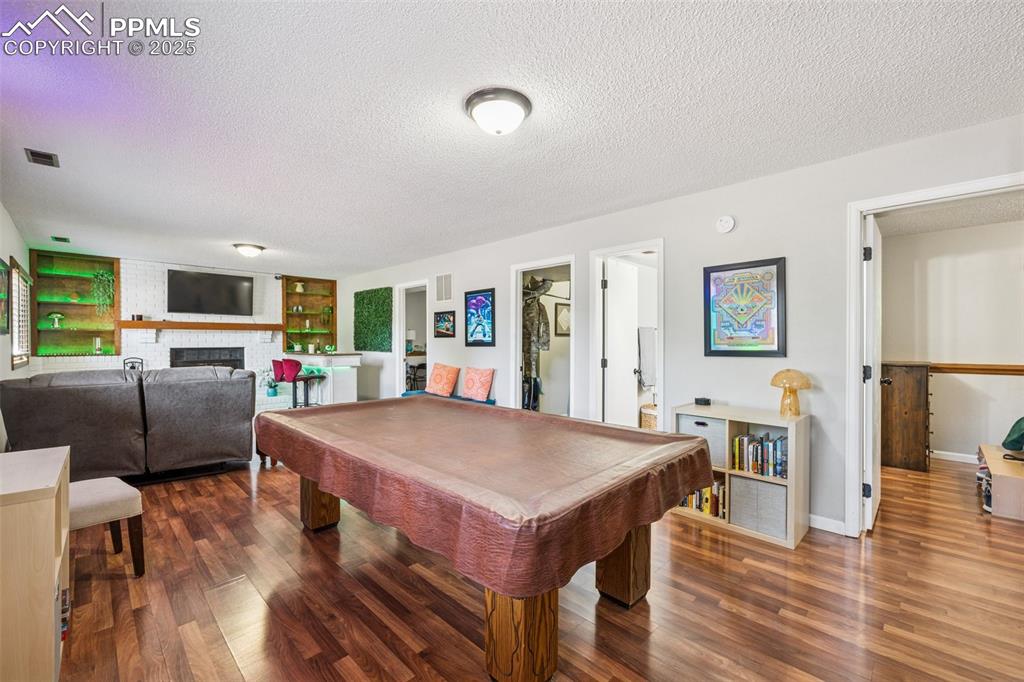 Image 20 of 25: Rec room featuring billiards, a textured ceiling, dark wood finished floors