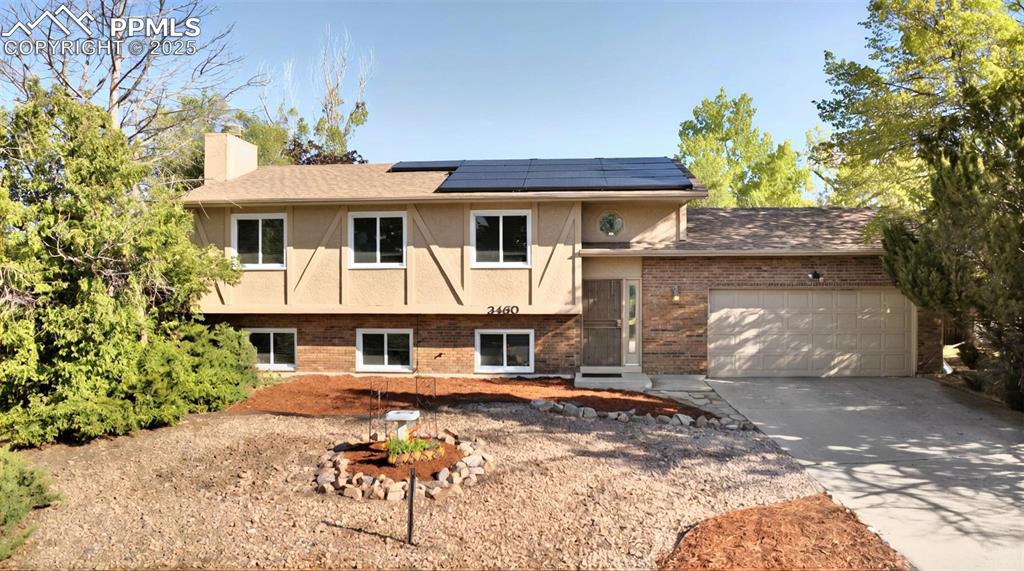 Image 25 of 25: View of front of property featuring solar panels, a chimney, brick siding,
