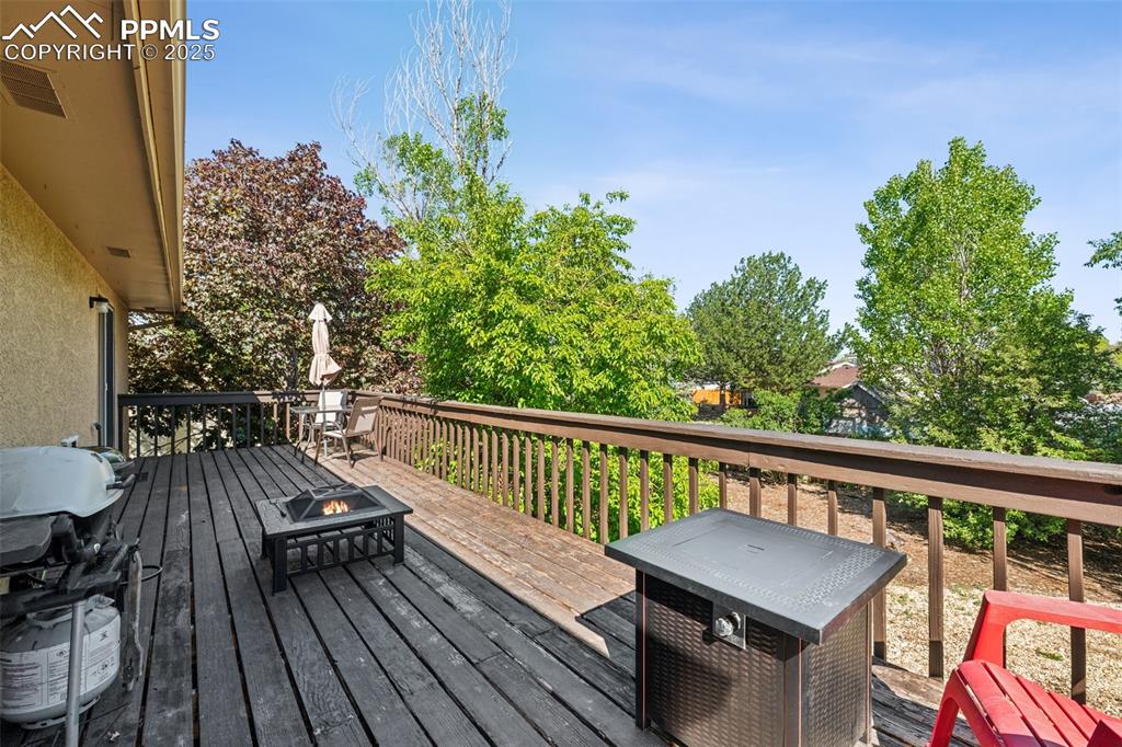 Image 3 of 25: Deck with a fire pit and a grill